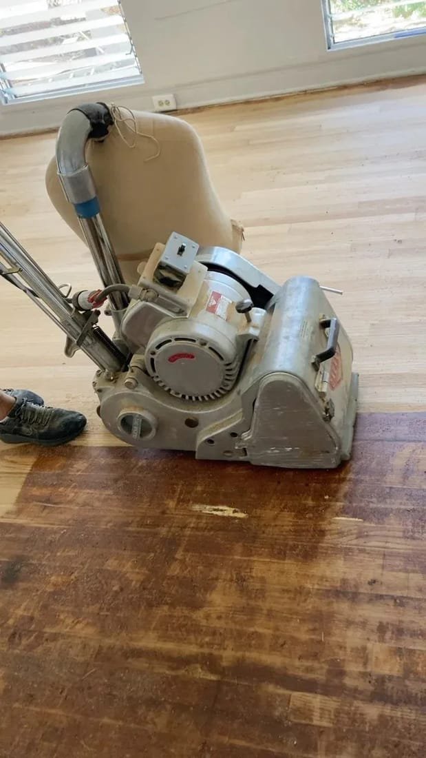 Floor sanding machine in action on a hardwood floor